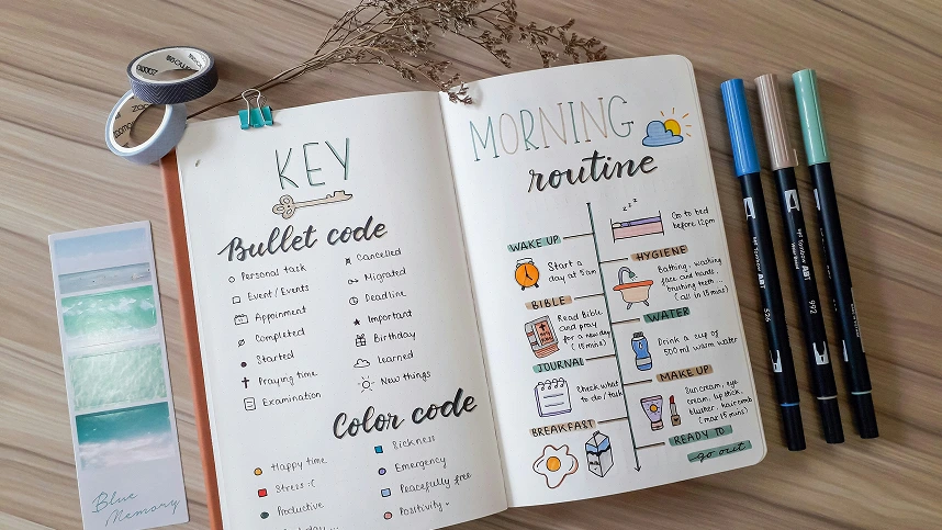 Bullet Journal con key list e morning routine illustrate, affiancato da pennarelli colorati